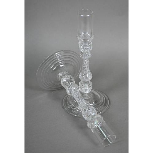 528 - A pair of antique glass candlesticks with plain cylindrical sockets on baluster stems with bubbles a... 