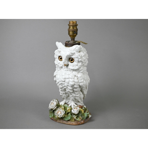 561 - A Victorian china lamp base, modelled as an owl standing on floral-encrusted base, with glass eyes, ... 