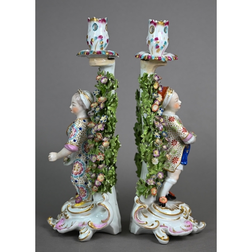 562 - A pair of Samson of Paris gold anchor candlesticks, modelled with flower-sellers on Rococo bases, 27... 