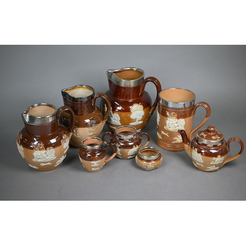 598 - Three Royal Doulton stoneware harvest jugs with silver rims, to/w a three-piece bachelor tea set and... 