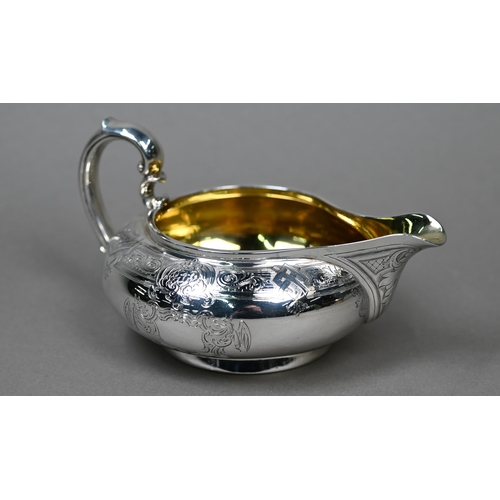 71 - A Victorian silver milk jug of compressed form with engraved decoration and scroll handle, Garrards,... 