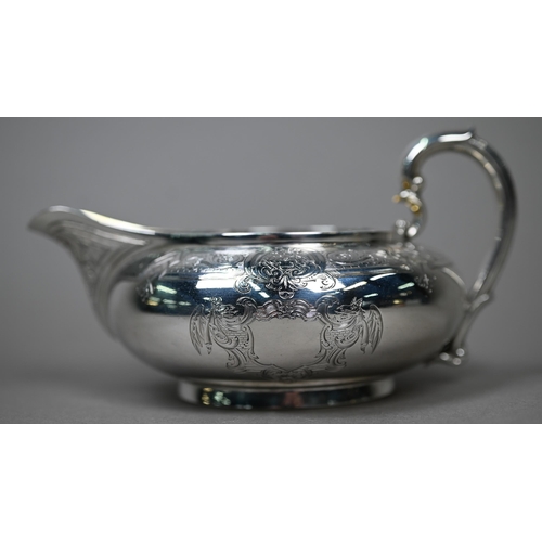 71 - A Victorian silver milk jug of compressed form with engraved decoration and scroll handle, Garrards,... 