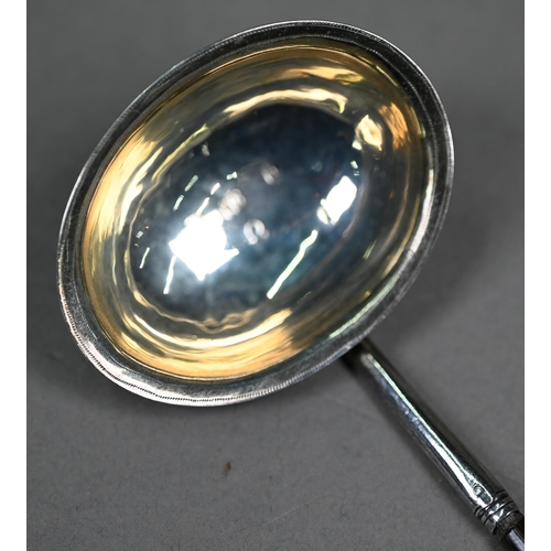 94A - A George III silver punch ladle, set with a gilt 1758 shilling, London 1788, on twisted whalebone st... 