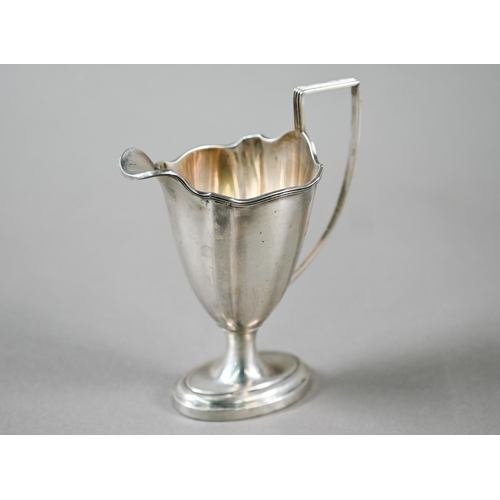 95 - An Edwardian Sheraton Revival silver urn-shaped cream jug on stemmed oval foot with reeded handle, M... 