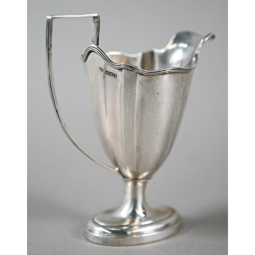 95 - An Edwardian Sheraton Revival silver urn-shaped cream jug on stemmed oval foot with reeded handle, M... 