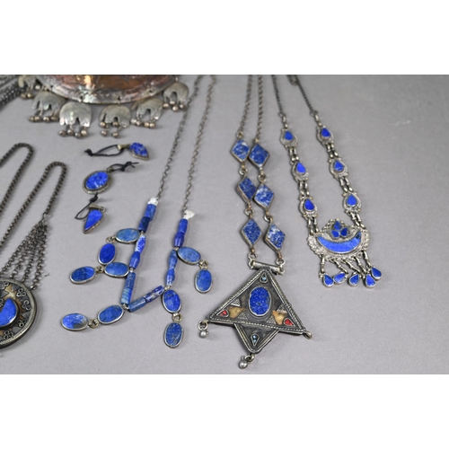 303 - A collection of various Afghan jewellery items including white metal pendants, necklaces, etc some s... 