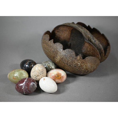 1159 - A Coco de Mer basket, containing seven polished stone eggs