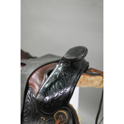 1170 - A vintage tooled leather American Western style saddle, with straps/stirrups but a/f