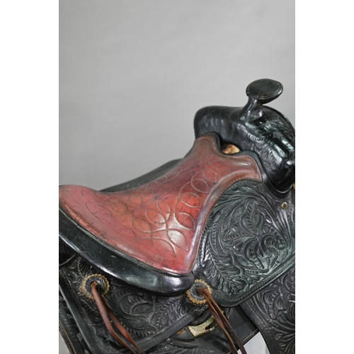 1170 - A vintage tooled leather American Western style saddle, with straps/stirrups but a/f