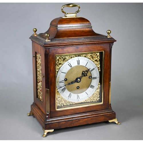 A 19th century brass mounted mahogany bracket clock, the three train movement striking on eight bells and a coiled gong, the silver chapter ring with Roman numerals and Arabic five minute markers, pierced gilt spandrels to each corner, four and eight bell lever, the case surmounted by a folding carrying handle and raised on brass bracket feet, 38 cm h o/all, movement door glass panel missing, with key