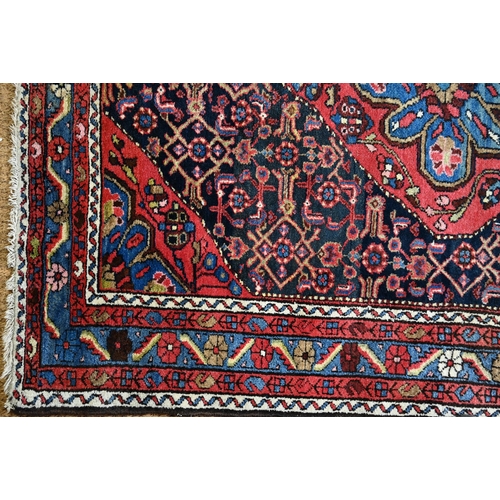 801 - An old Persian Hamadan rug, the blue ground centered by a red ground medallion, 92 cm x 142 cm