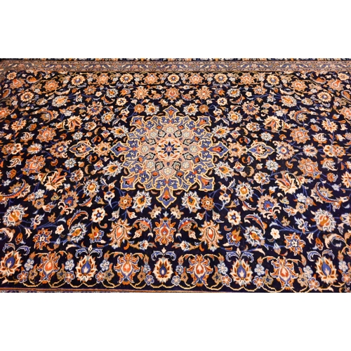 802 - Central Persian signed Kashan carpet, predominantly blue centred by a floral medallion, 380 cm x 270... 