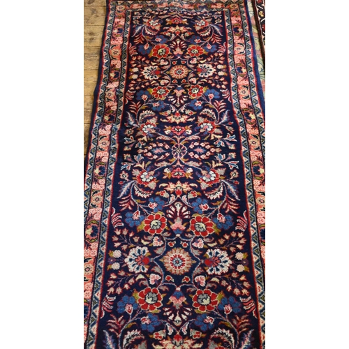 805 - A Persian Hamadan runner, the repeating stylised design on blue ground, 380 cm x 83 cm