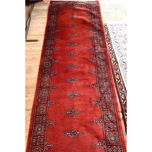 806 - A Bokhara long red ground runner of repeating designs, 629 x 79 cm