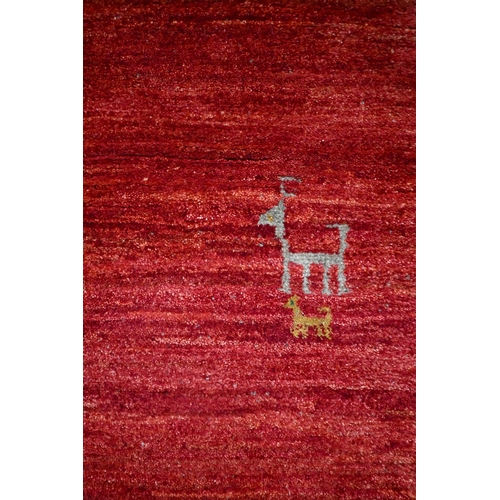 807 - A contemporary South West Persian Gabbeh, the mottled mid-red ground scattered with stylised deer/ho... 