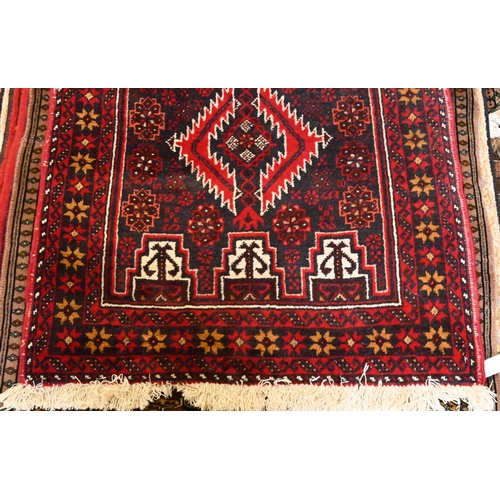 809 - A contemporary Persian Meshad Baluchi design runner, the diamond pole design on navy ground, 200 cm ... 