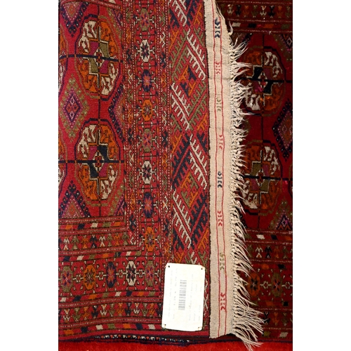 810 - A traditional Russian Turkoman rug, the brown red ground with two rows of guls, 133 cm x 74 cm, mid ... 