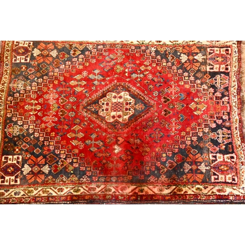 816 - An old Persian Shiraz rug, the red ground of stylised flowers centred by a medallion, 160 cm x 114 c... 