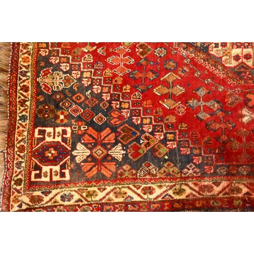 816 - An old Persian Shiraz rug, the red ground of stylised flowers centred by a medallion, 160 cm x 114 c... 