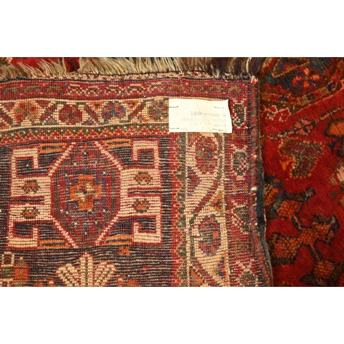 816 - An old Persian Shiraz rug, the red ground of stylised flowers centred by a medallion, 160 cm x 114 c... 