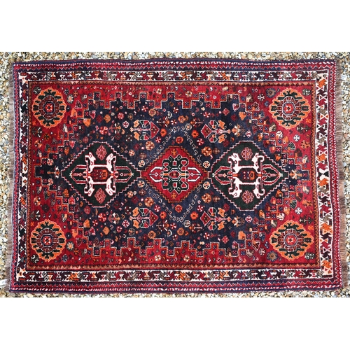 817 - A Persian Shiraz rug, the triple lozenge design on blue-brown ground, 162 cm x 116 cm