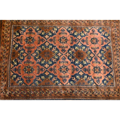 819 - An old brown ground Baluch rug, 188 cm x 128 cm