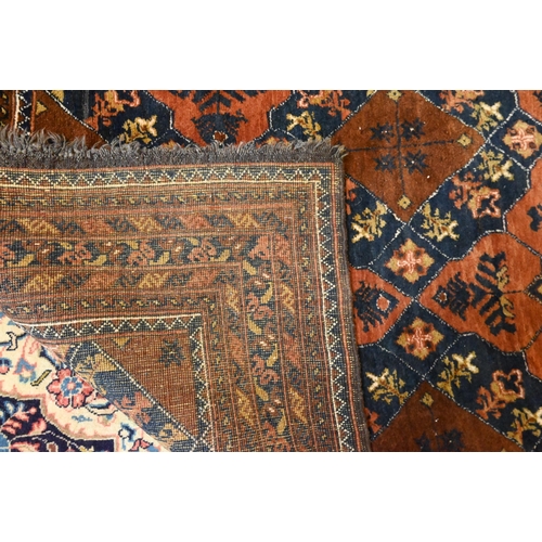 819 - An old brown ground Baluch rug, 188 cm x 128 cm