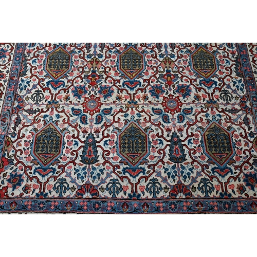 821 - An antique Persian Kashan rug, the repeating design of floral vines on camel ground, 208 cm x 138 cm