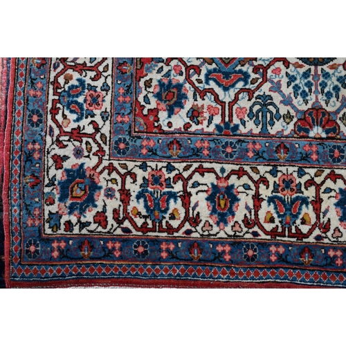 821 - An antique Persian Kashan rug, the repeating design of floral vines on camel ground, 208 cm x 138 cm