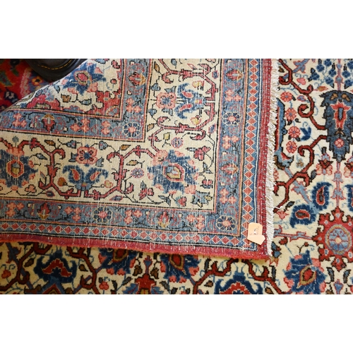 821 - An antique Persian Kashan rug, the repeating design of floral vines on camel ground, 208 cm x 138 cm