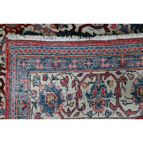 821 - An antique Persian Kashan rug, the repeating design of floral vines on camel ground, 208 cm x 138 cm