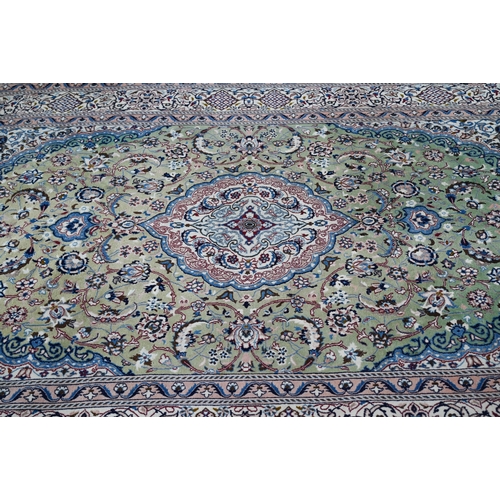 823 - An old Indo-Persian Nian carpet, the cream ground centred with a pale green ground floral medallion,... 