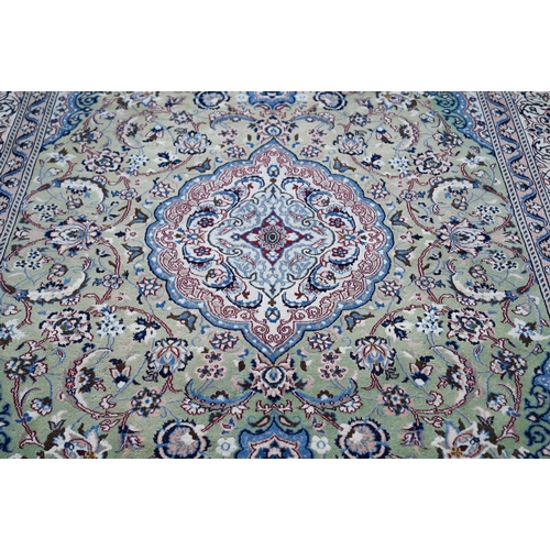 823 - An old Indo-Persian Nian carpet, the cream ground centred with a pale green ground floral medallion,... 