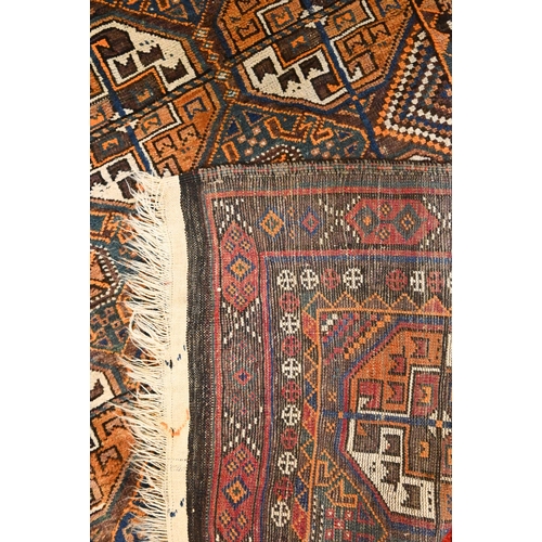 826 - An antique Kurdish rug runner, the field of octagonal tiles on blue-brown ground, 226 cm x 117 cm