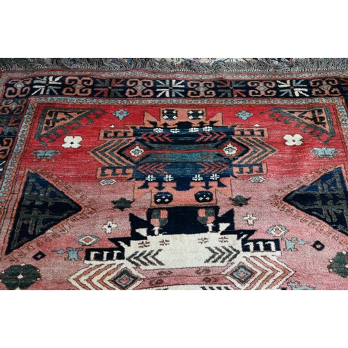 827 - A mid-century Turkish rug, faded red ground rug with geometric design, 228 cm x 164 cm