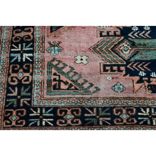 827 - A mid-century Turkish rug, faded red ground rug with geometric design, 228 cm x 164 cm