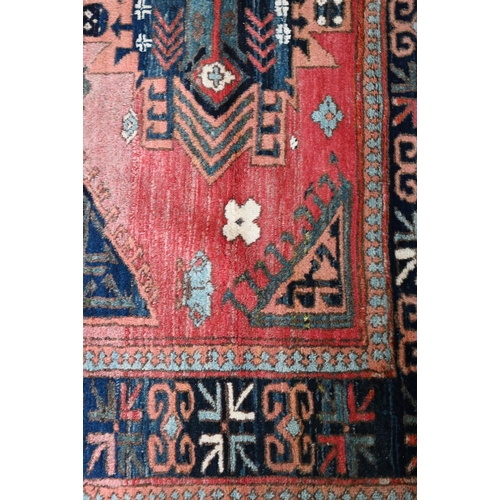 827 - A mid-century Turkish rug, faded red ground rug with geometric design, 228 cm x 164 cm