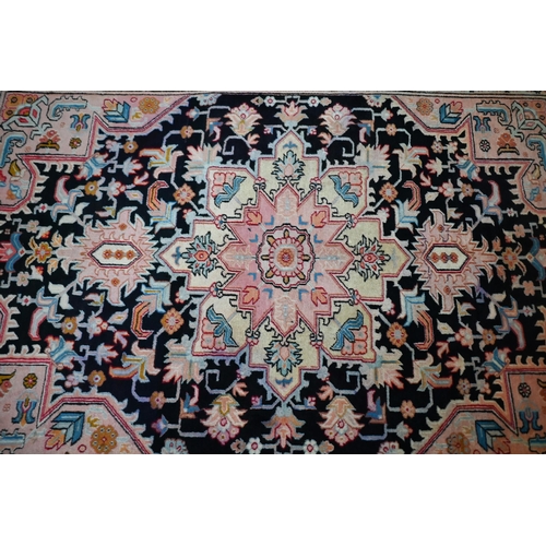 830 - A contemporary North West Persian Heriz rug, the pink design on black ground, 195 cm x 145 cm