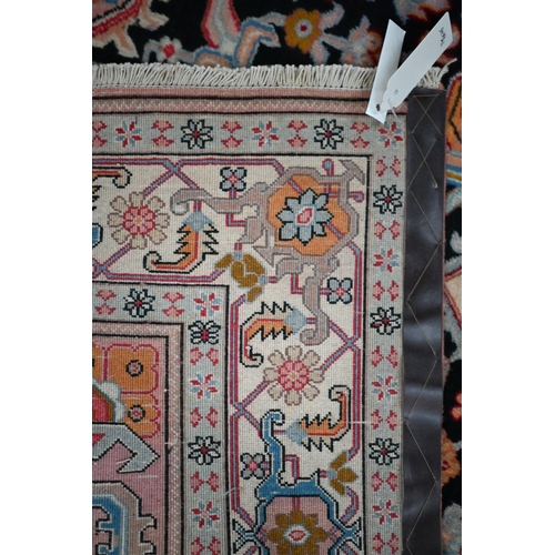 830 - A contemporary North West Persian Heriz rug, the pink design on black ground, 195 cm x 145 cm