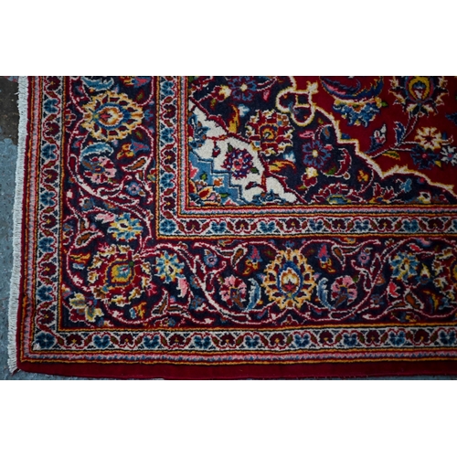 832 - An old central Persian Kashan rug, the wine-red ground centred by a blue ground floral medallion, 21... 