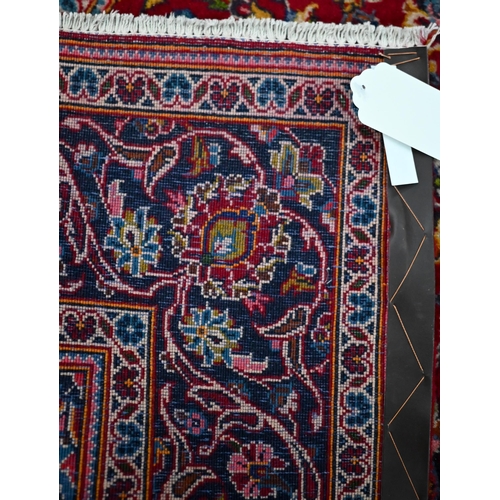 832 - An old central Persian Kashan rug, the wine-red ground centred by a blue ground floral medallion, 21... 