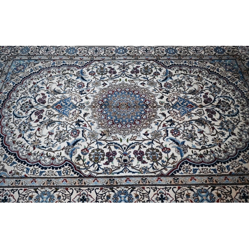 839 - A central Persian Nain carpet of classical floral garden design, executed in blues, brown on camel g... 