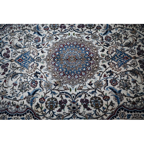 839 - A central Persian Nain carpet of classical floral garden design, executed in blues, brown on camel g... 