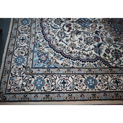 839 - A central Persian Nain carpet of classical floral garden design, executed in blues, brown on camel g... 