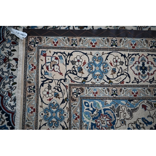 839 - A central Persian Nain carpet of classical floral garden design, executed in blues, brown on camel g... 