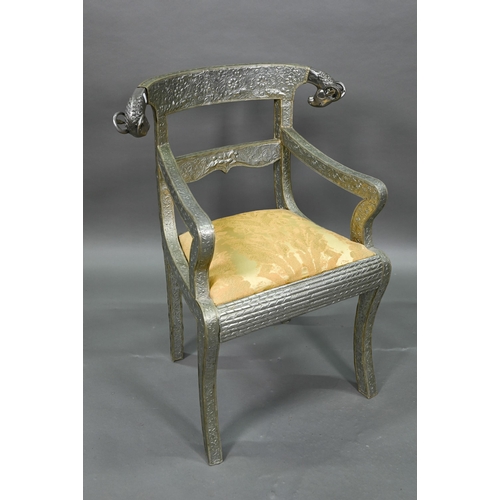 865 - A pair of Indian metal clad dining hall chairs, with rams head back terminals over sabre front legs ... 