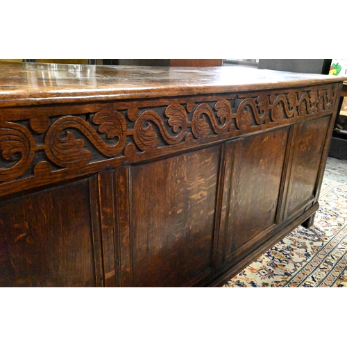 867 - A very large early 18th century oak coffer, the three plank top over a moulded frieze and four panel... 