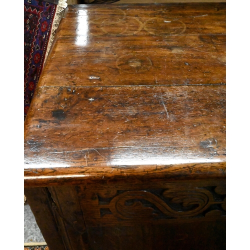 867 - A very large early 18th century oak coffer, the three plank top over a moulded frieze and four panel... 