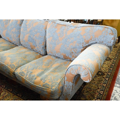 873 - An walnut and upholstered three-seat sofa with blue and brown/gold upholstery / cushions, raised on ... 