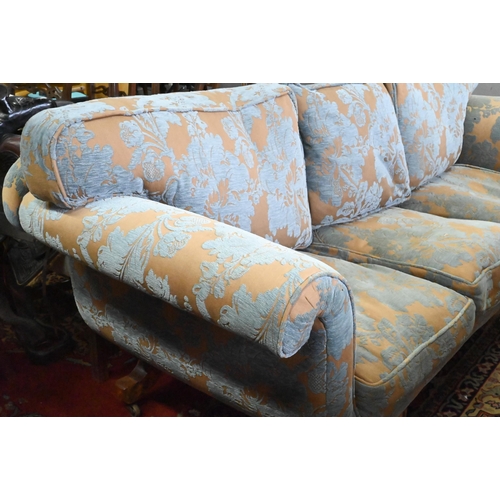 873 - An walnut and upholstered three-seat sofa with blue and brown/gold upholstery / cushions, raised on ... 